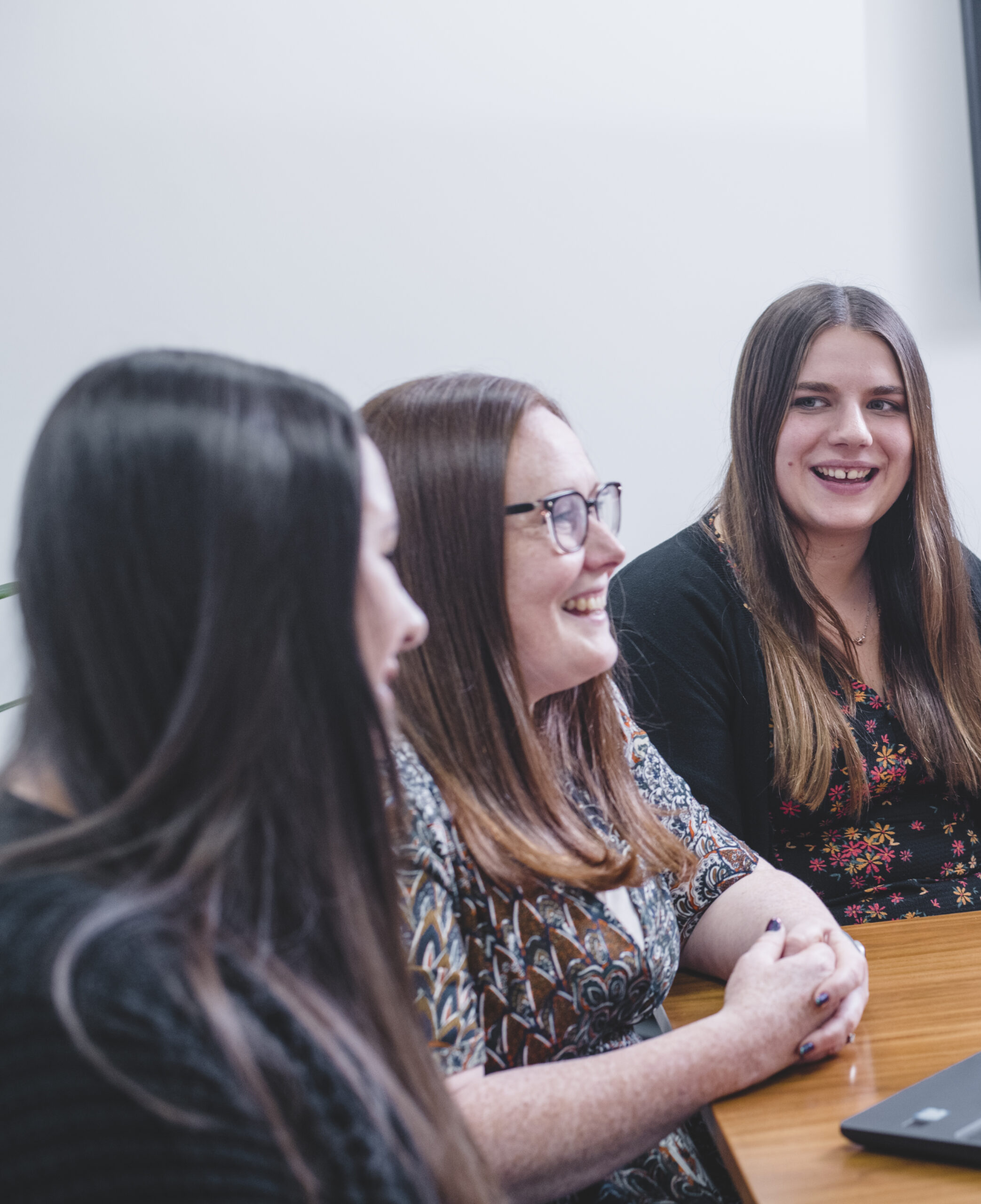 Why work with Griffin - Three female team members say at an office desk.